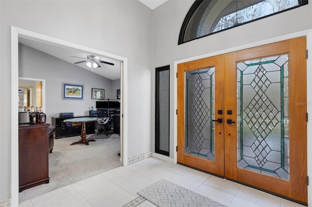 foyer entrance featuring carpet floors, french doors, high vaulted ceiling, and tile patterned floors