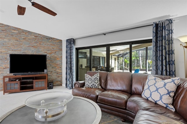 living area with a ceiling fan and vaulted ceiling