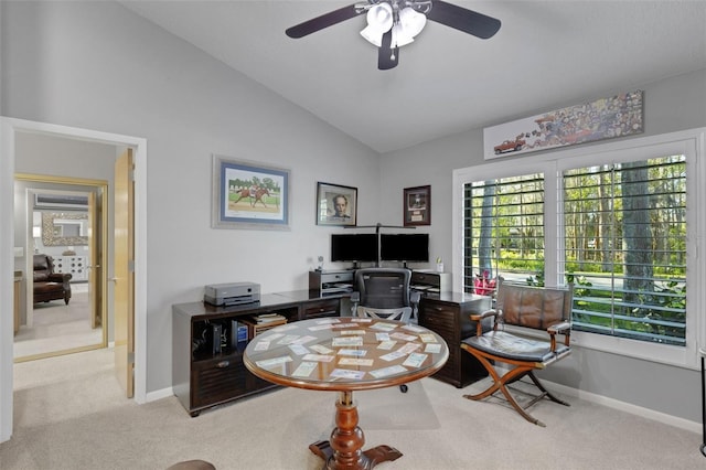 office area featuring baseboards, vaulted ceiling, a ceiling fan, and light colored carpet