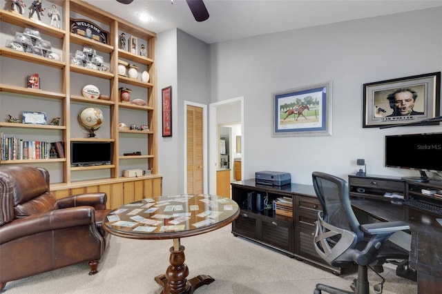 carpeted office space with a ceiling fan