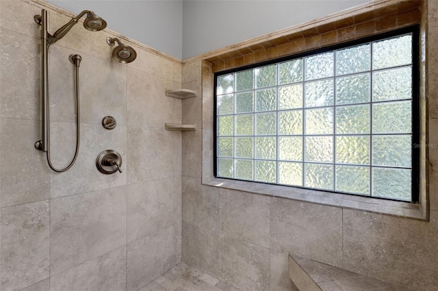 full bath with a healthy amount of sunlight and tiled shower