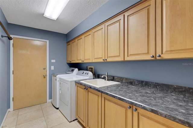 laundry room featuring light tile patterned floors, a textured ceiling, separate washer and dryer, a sink, and cabinet space