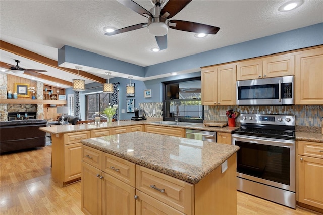 kitchen featuring vaulted ceiling with beams, stainless steel appliances, backsplash, a center island, and light brown cabinetry