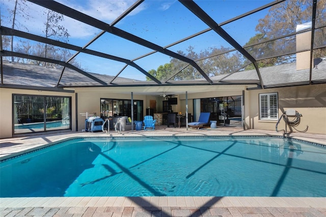 pool with glass enclosure and a patio area