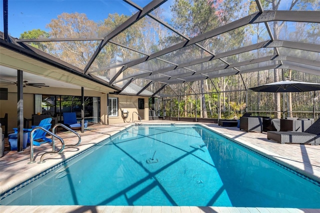 outdoor pool with a lanai, ceiling fan, and a patio