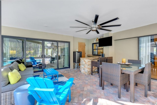 view of patio / terrace with outdoor dry bar, outdoor dining space, and a ceiling fan