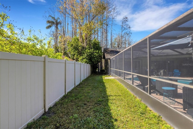 view of yard with a patio, a lanai, fence, and an outdoor pool