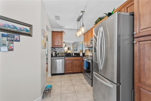 kitchen featuring light tile patterned floors, visible vents, dark countertops, brown cabinets, and stainless steel appliances