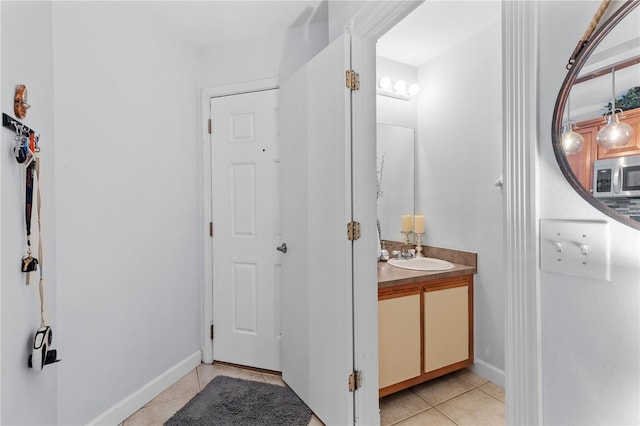 bathroom with tile patterned flooring, vanity, and baseboards