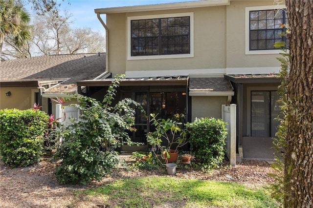 view of front of house featuring a shingled roof and stucco siding