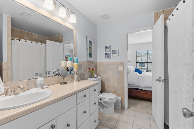 bathroom with visible vents, connected bathroom, toilet, tile patterned flooring, and tile walls