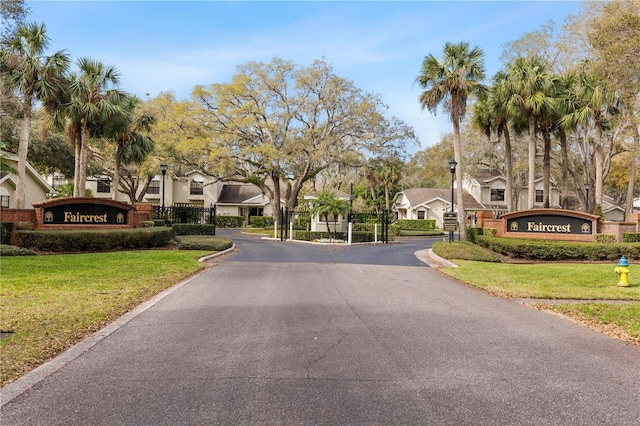 view of road featuring a residential view, a gated entry, and street lights