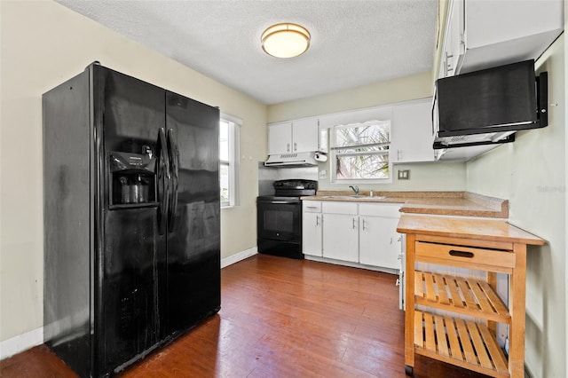 kitchen featuring black appliances, light countertops, white cabinetry, and under cabinet range hood