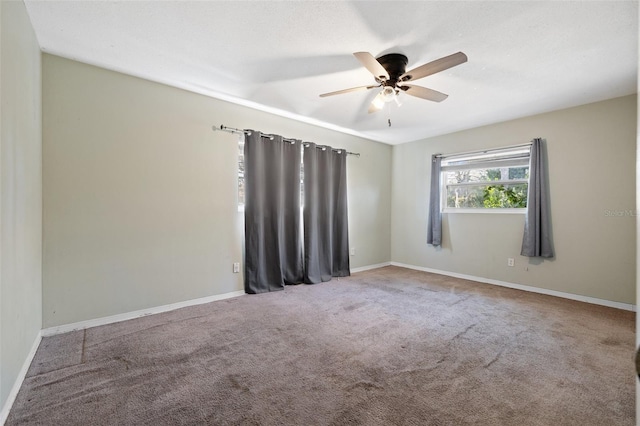 empty room featuring ceiling fan, carpet flooring, and baseboards