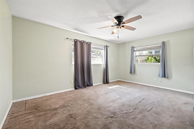 spare room featuring a ceiling fan, carpet, a textured ceiling, and baseboards