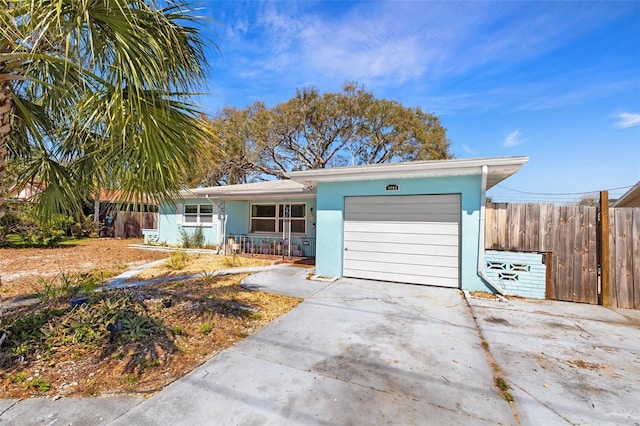 view of front of property with an attached garage, covered porch, fence, driveway, and stucco siding