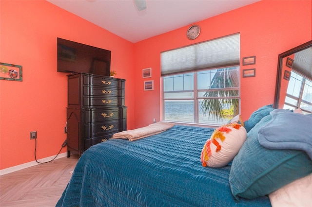 bedroom featuring multiple windows, a ceiling fan, and baseboards