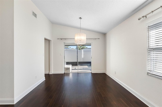 spare room with lofted ceiling, wood finished floors, baseboards, and a chandelier