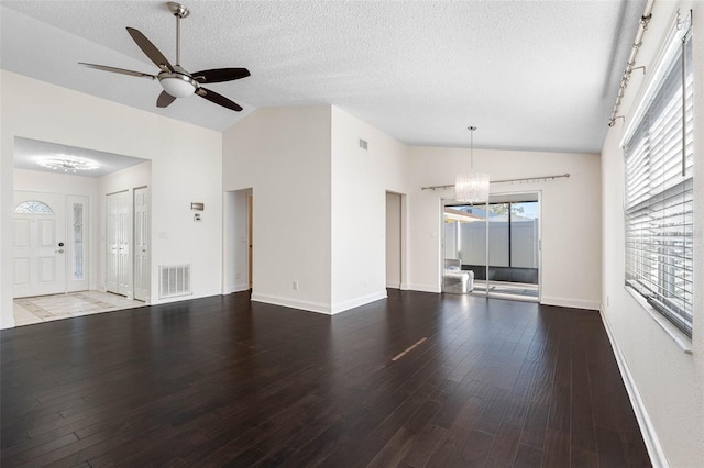 unfurnished living room featuring visible vents, ceiling fan with notable chandelier, a textured ceiling, wood finished floors, and vaulted ceiling