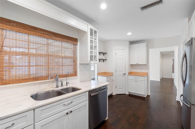 kitchen featuring visible vents, a sink, dark wood-type flooring, glass insert cabinets, and appliances with stainless steel finishes