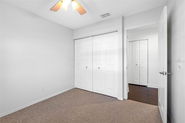 unfurnished bedroom featuring a closet, visible vents, baseboards, and carpet