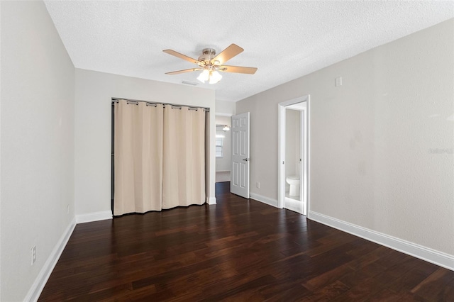 unfurnished bedroom featuring visible vents, baseboards, a textured ceiling, and wood finished floors