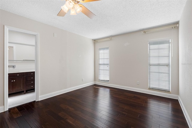 spare room featuring baseboards, a textured ceiling, dark wood-style flooring, and a ceiling fan