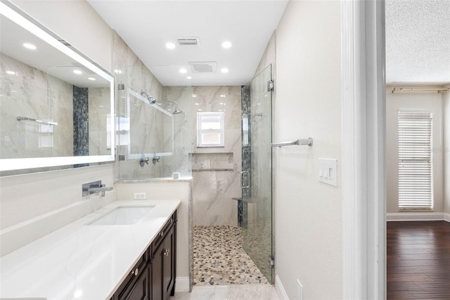 bathroom featuring recessed lighting, a marble finish shower, visible vents, and vanity