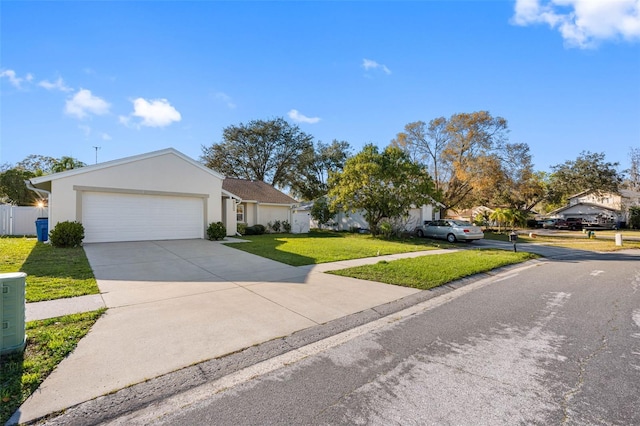 ranch-style house featuring fence, a front yard, stucco siding, a garage, and driveway