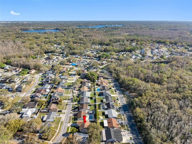 bird's eye view featuring a residential view, a water view, and a wooded view