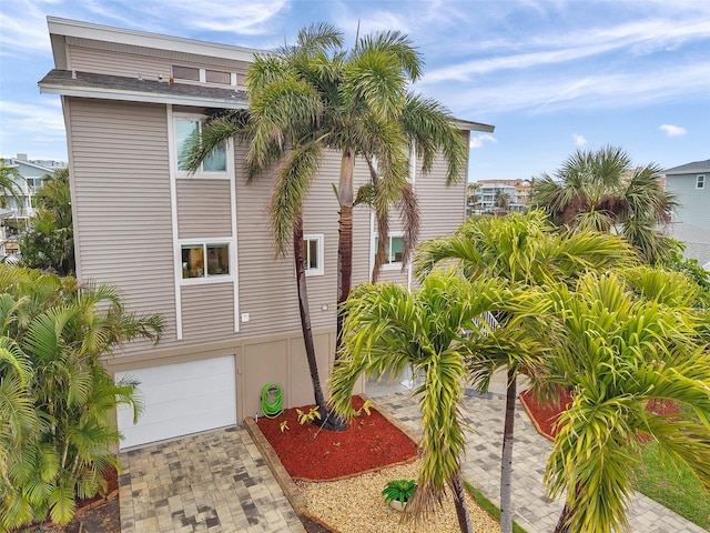 17404 1st St E, Redington Shores, FL 33708 - view of side of property featuring a garage and decorative driveway