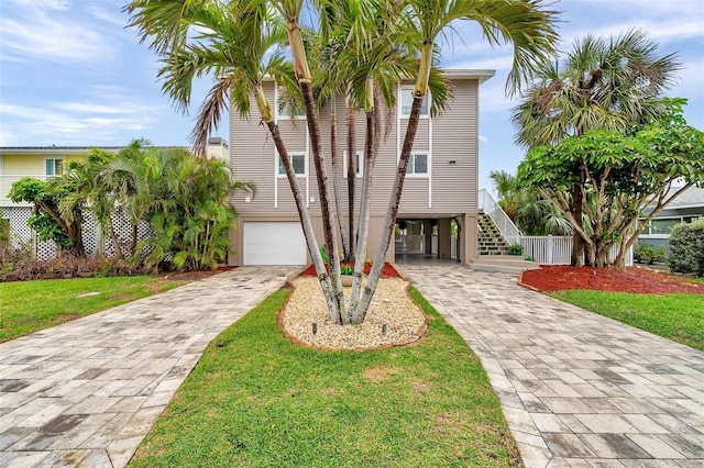 17404 1st St E, Redington Shores, FL 33708 - beach home with decorative driveway, a carport, stairs, an attached garage, and a front lawn