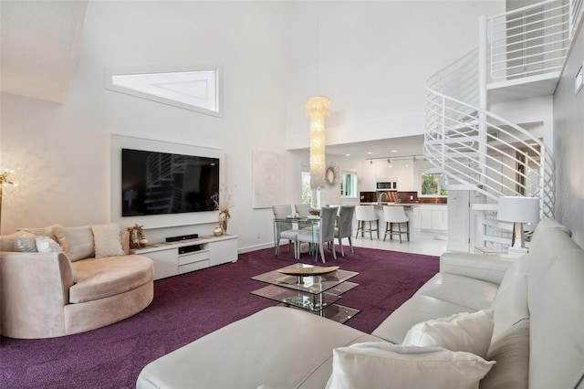 17404 1st St E, Redington Shores, FL 33708 - living area with a towering ceiling, stairway, carpet flooring, and baseboards