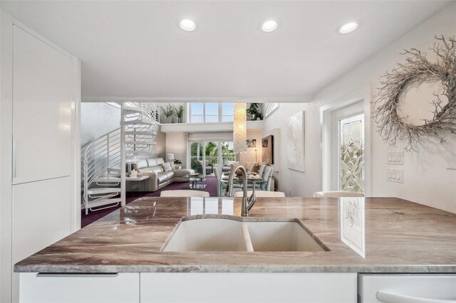 17404 1st St E, Redington Shores, FL 33708 - kitchen featuring a sink, dishwasher, recessed lighting, white cabinetry, and light stone countertops