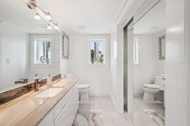 17404 1st St E, Redington Shores, FL 33708 - full bathroom with toilet, tile patterned floors, healthy amount of natural light, and vanity