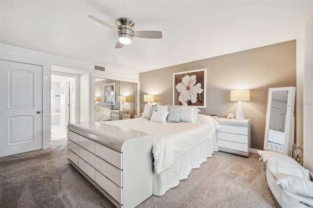 17404 1st St E, Redington Shores, FL 33708 - bedroom with light colored carpet, ensuite bathroom, ceiling fan, and a closet