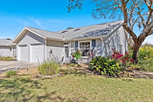 ranch-style home with an attached garage, driveway, a shingled roof, and a front yard