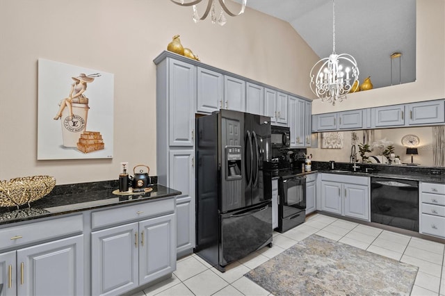 kitchen featuring a sink, vaulted ceiling, gray cabinets, black appliances, and an inviting chandelier