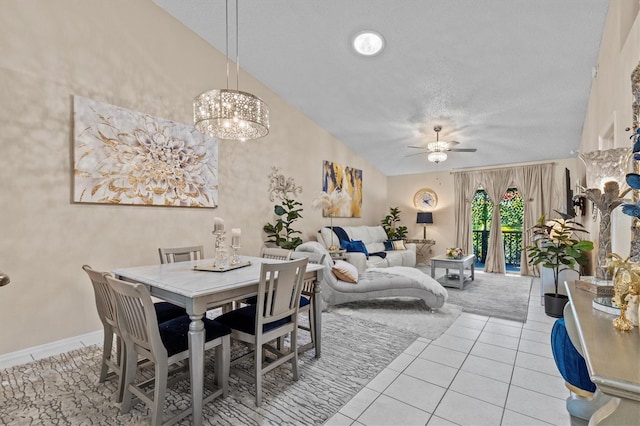 tiled dining room featuring a textured ceiling, baseboards, vaulted ceiling, and a ceiling fan