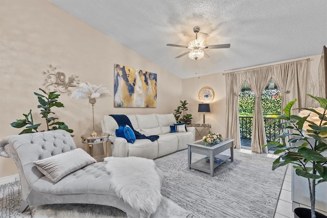 living room with a textured ceiling, vaulted ceiling, a ceiling fan, and tile patterned floors