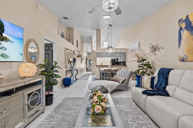 living room with light tile patterned floors, high vaulted ceiling, a textured ceiling, visible vents, and a ceiling fan