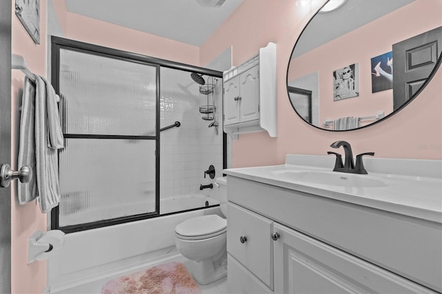 bathroom featuring bath / shower combo with glass door, vanity, and toilet