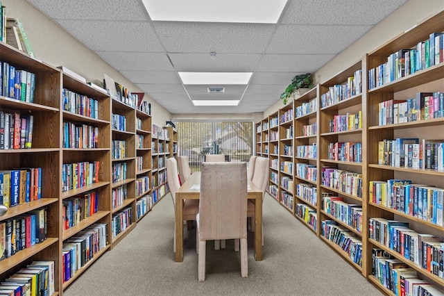 interior space with bookshelves, a drop ceiling, and visible vents