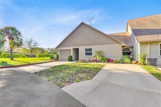 ranch-style house with stucco siding, concrete driveway, an attached garage, cooling unit, and a front lawn