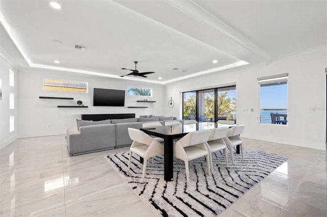 dining area with visible vents, baseboards, crown molding, and a tray ceiling