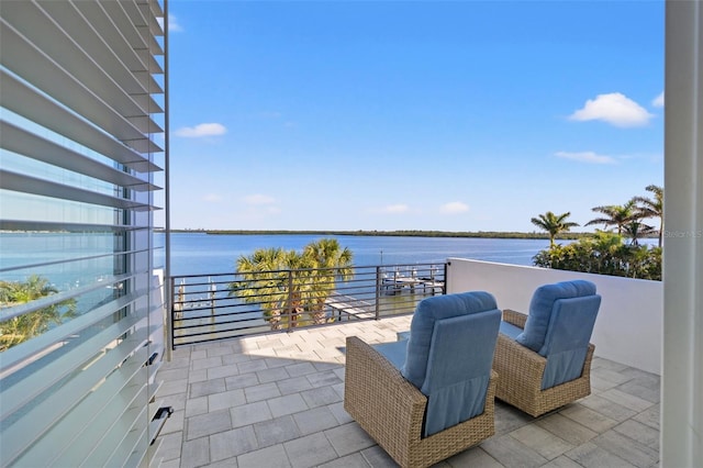 view of patio with a water view and a balcony