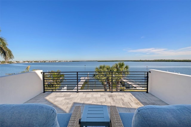 view of patio with a balcony and a water view