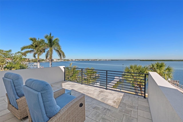 view of patio / terrace with a balcony and a water view