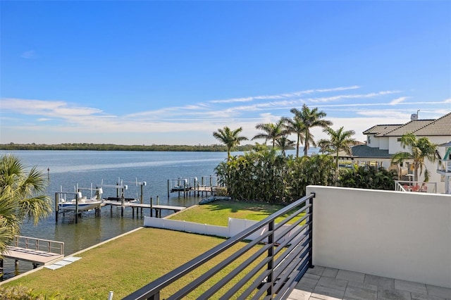 view of dock featuring a balcony, a yard, a water view, and boat lift