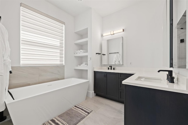 bathroom with vanity, a soaking tub, built in features, and marble finish floor